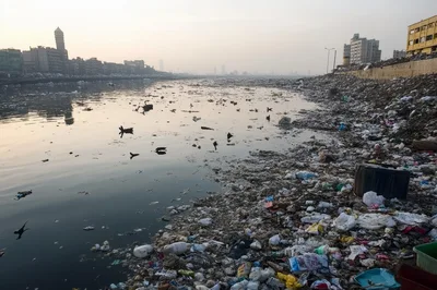 Polluted Riverbank With Massive Accumulation Of Plastic Waste