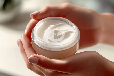 Woman Holding Open Jar Of White Face Cream