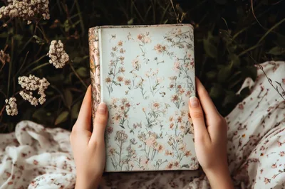 Woman Holding Vintage Floral Journal In A Meadow