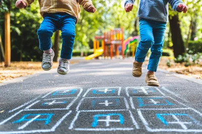 Children Playing Hopscotch on a Sunny Park Path