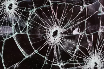 Shattered Glass Surface With Multiple Bullet Hole Impacts