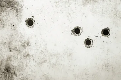 Four Circular Drill Holes In A Concrete Wall