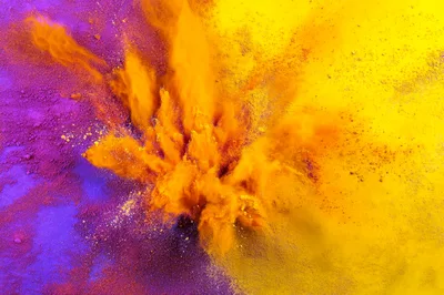 Vibrant Orange Powder Explosion Against Purple And Yellow Background