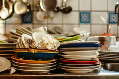 Stack Of Dirty Dishes In A Kitchen Sink
