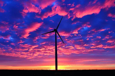 Wind Turbine Silhouette Against A Vibrant Sunset Sky