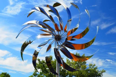 Kinetic Metal Wind Sculpture Rotating Against Blue Sky