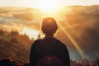 Woman Standing Alone Watching A Golden Sunrise