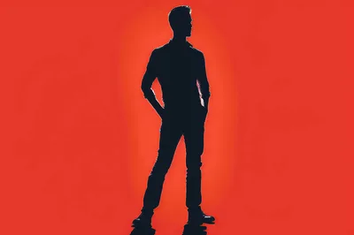 Silhouette Of A Man Standing Against Red Background