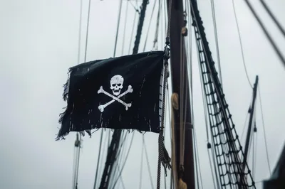 Tattered Pirate Flag Flying From A Ship Mast