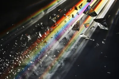 Abstract Shattered Glass Fragments Floating Through Colorful Light Beams