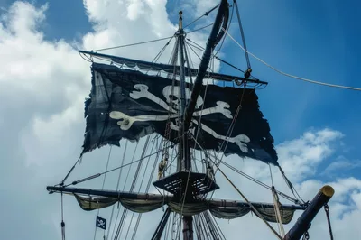Tattered Jolly Roger Flag Flying On Pirate Ship Mast