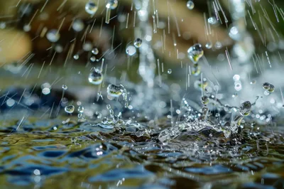 Macro Close Up Of Raindrops Splashing Into Water