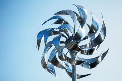 Spinning Metal Wind Spinner Sculpture Against Blue Sky