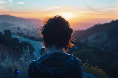 Person Standing Alone Looking At Sunset Over Mountains