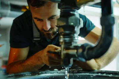 Professional Plumber Repairing Leaking Sink Pipe
