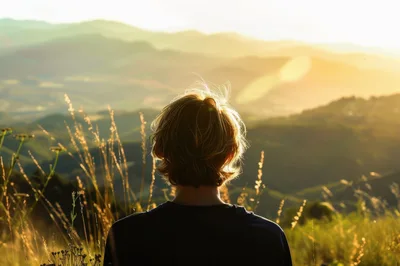 Person Looking Over Rolling Hills At Sunset