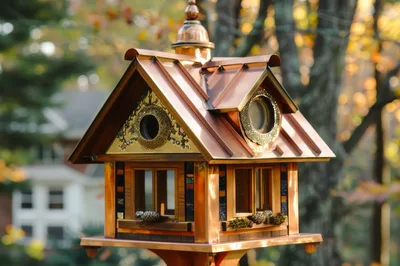Decorative Wooden Birdhouse With Copper Roof In Autumn
