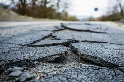 Damaged Asphalt Road Surface With Deep Cracks