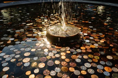 Coins Tossed Into A Decorative Water Fountain