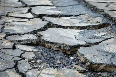 Cracked Asphalt Surface With Deep Fissures