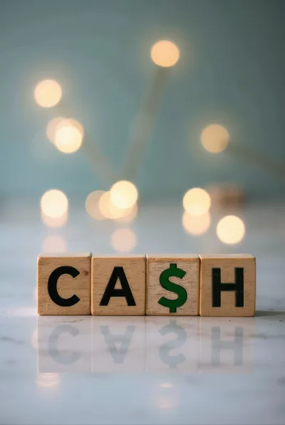Wooden Blocks Spelling Cash on Reflective Surface