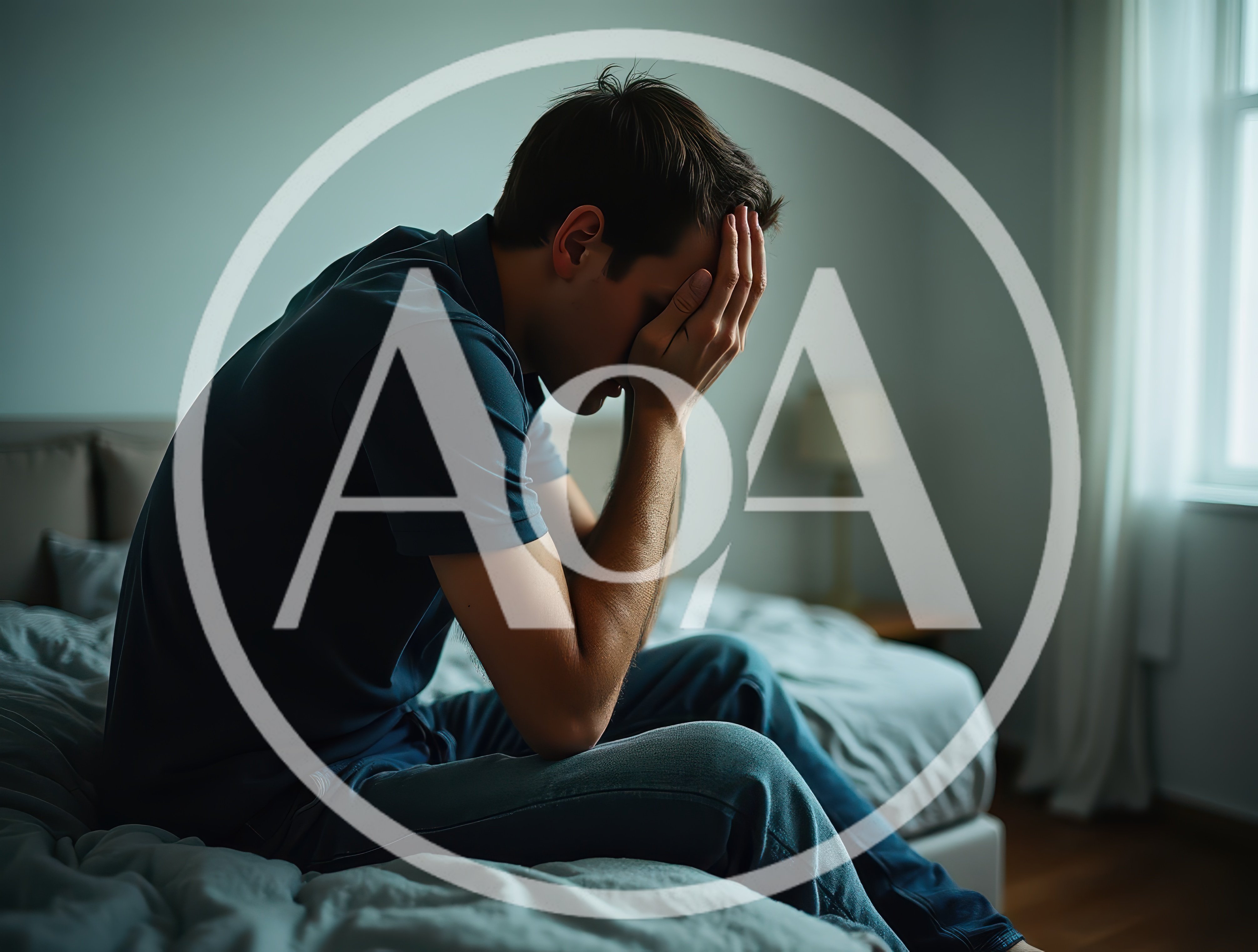Depressed Young Man Sitting Alone On Bed