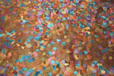 Colorful Confetti Scattered Over A Shimmering Gold Surface