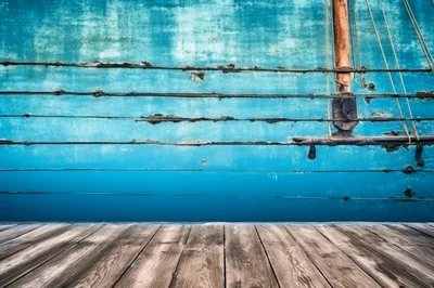 Weathered Blue Wooden Boat Hull Beside A Dock