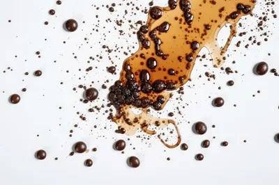Coffee Beans and Spilled Liquid on White Background