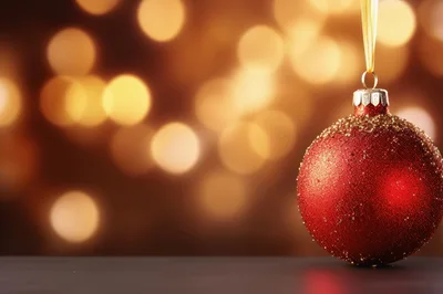 Red Glitter Christmas Ornament Hanging Against Bokeh Background
