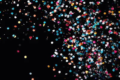 Colorful Confetti Falling Against A Black Background