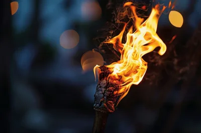 Burning Tiki Torch Against A Dark Blurred Background