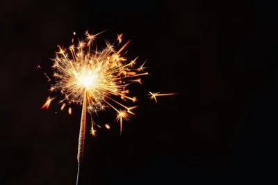 Bright Burning Sparkler Against Dark Background