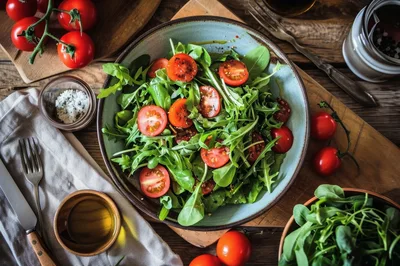 Fresh Arugula Salad With Cherry Tomatoes In Rustic Bowl