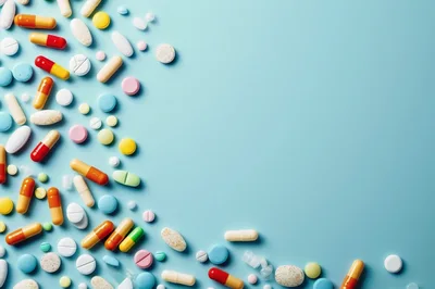 Assorted Pharmaceutical Pills and Capsules on Blue Background