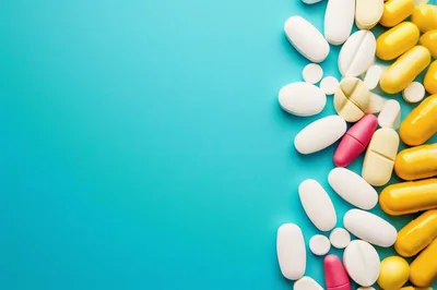 Assorted Pharmaceutical Pills and Capsules on Blue Background