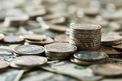 Stack Of Euro Coins On American Dollar Bills