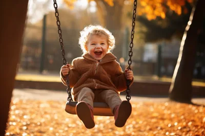Happy Toddler Swinging In Autumn Park