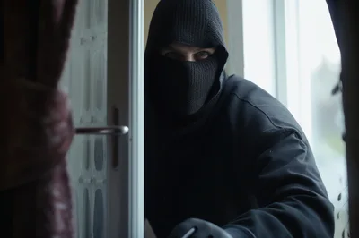 Intruder Wearing Balaclava Peering Through A Window
