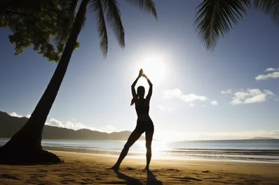 Woman Practicing Yoga Silhouette On Tropical Beach