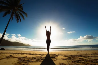 Woman Practicing Yoga On A Tropical Beach At Sunrise