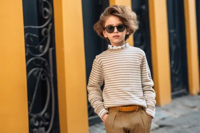 Stylish Young Boy Posing In Striped Sweater And Sunglasses