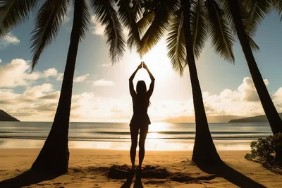 Woman Silhouette Stretching Arms Under Palm Trees At Sunset
