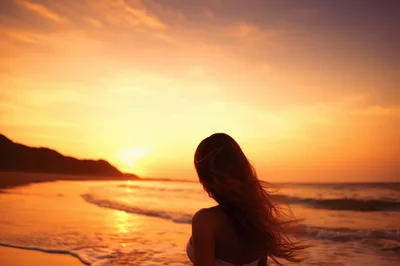 Woman Standing On Beach At Sunset