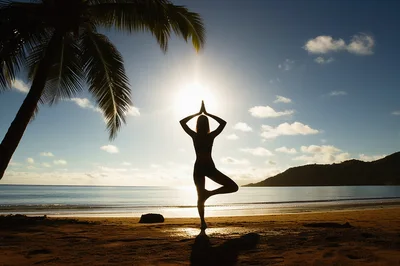 Woman Practicing Tree Pose Yoga On Tropical Beach