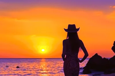 Silhouette of a Woman in a Cowboy Hat at Sunset