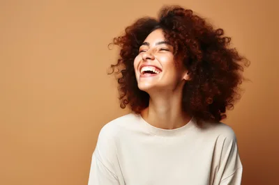 Joyful Young Woman With Curly Hair Laughing