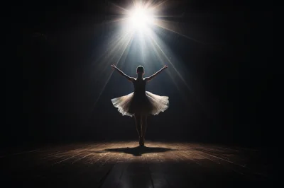 Ballerina Performing Under Dramatic Spotlight On Stage