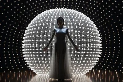 Futuristic Woman Standing Before A Glowing Light Sphere
