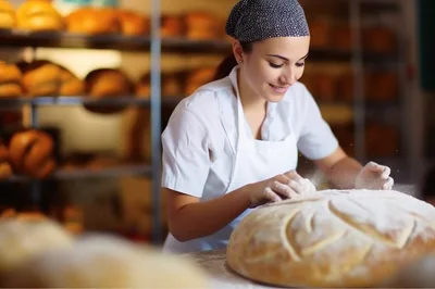Female Baker Preparing Fresh Sourdough Bread In Bakery
